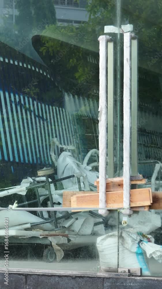 Poster abstract view through a glass window showing a cluttered construction site and reflections of a mode