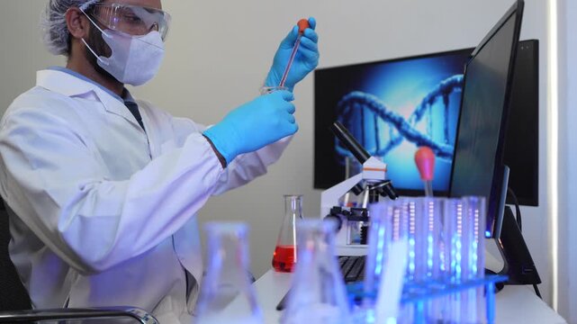 A geneticist performs microscopic analysis of a cellular sample, cross-referencing observations with genomic data displayed on a bioinformatics workstation in a biotech lab.