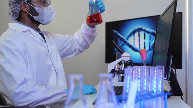 A geneticist performs microscopic analysis of a cellular sample, cross-referencing observations with genomic data displayed on a bioinformatics workstation in a biotech lab.