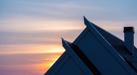 Silhouette of modern house roof against colorful sunset sky