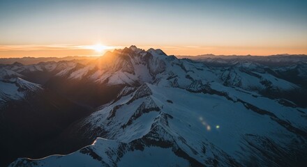 Golden Sunrise Illuminating Snow-Capped Mountain Peaks in a Vast Alpine Landscape