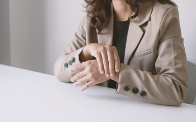 Business woman massaging wrist in pain caused by working on a computer keyboard for a long time, wrist pain and numbness in the wrist. While working at the office