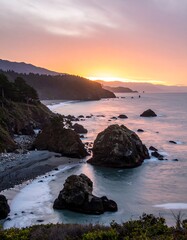 Coastal sunset over rocks and beach