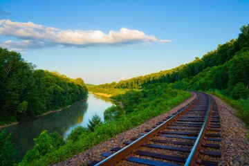 Scenic Railway Following River Through Lush Forest Landscape