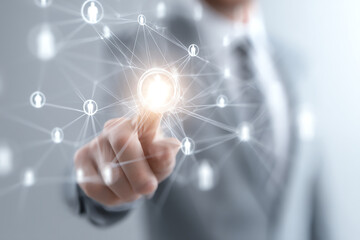 Fototapeta premium Businessperson in a suit interacting with a glowing network interface representing digital connections and human resource management