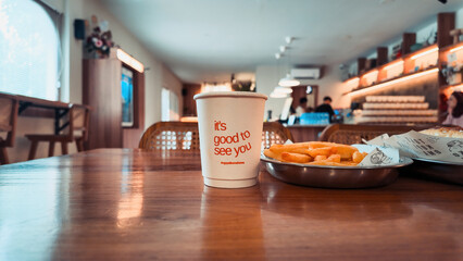 Cup of Coffee and Fries on Wooden Table in Cafe Setting