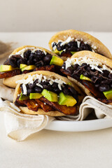 Homemade Venezuelan arepas stuffed with black beans, avocado, fried plantains, and cheese