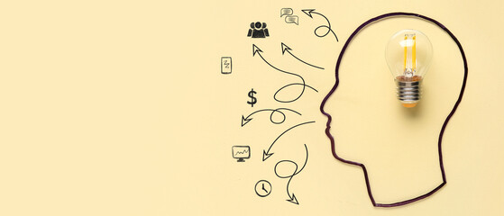 Silhouette of human head with light bulb on yellow background. Logic concept