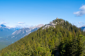 Views of Banff's majestic mountain peaks and lush forested landscape under a clear blue sky