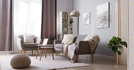Interior of modern living room with grey sofa, armchair and coffee table