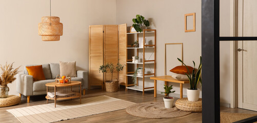 Interior of modern living room with grey sofa, coffee table and folding screen