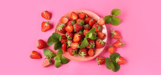Plate with sweet strawberries on pink background, top view