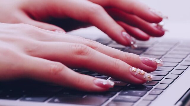 ネイルアートの指でパソコンのキーボードをたたく