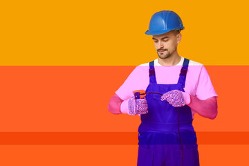 Portrait of male electrician with crimper and wire on yellow background