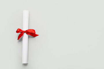 Diploma with red ribbon on white background