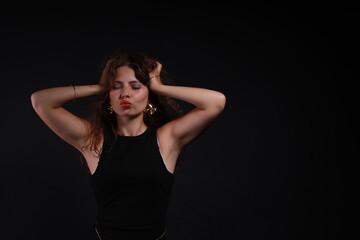 Low key portrait of pretty brunette woman in black dress