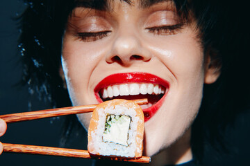 Happy model enjoying sushi with vibrant smile and chopsticks, featuring a dark background and...