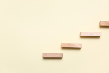 Ladder made of wooden blocks on beige background