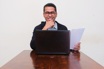 A company manager on his working desk smiling confident at the camera