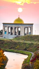 Obraz premium Blurry sunrise view of a temple, canal, and hillside