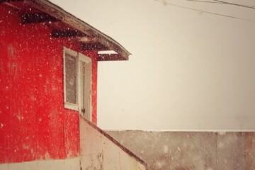 Red building in snowy weather, partially visible