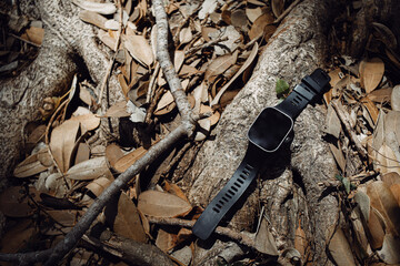 black smart watch on wood roots background
