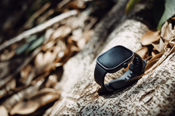 black smart watch on wood roots background
