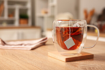 Glass cup of black tea on table in kitchen