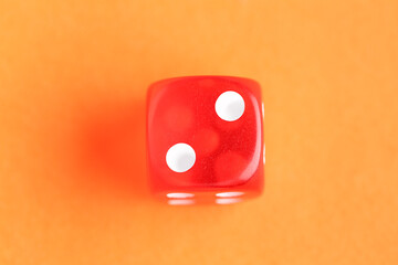 Red game dice on orange background