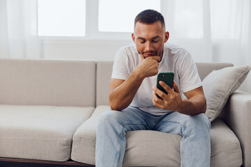 Thoughtful man browsing his phone, reflecting on digital connections and personal growth in the...
