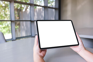 Mockup image of a woman holding digital tablet with blank white desktop screen