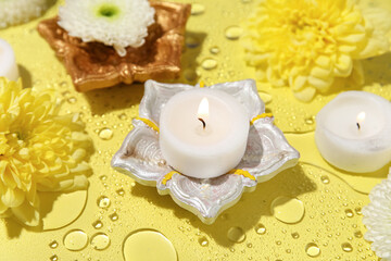 Diya lamps with candles and chrysanthemum flowers in water on yellow background. Divaly celebration