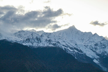 Jagged, snowy peaks loom under a cloudy sky Meili Snow Mountain Yala Snow Mountain, Sichuan, China