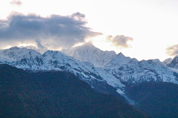 Jagged, snowy peaks loom under a cloudy sky Meili Snow Mountain Yala Snow Mountain, Sichuan, China