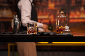 Bartender woman pours whiskey into a glass in a restaurant.	
