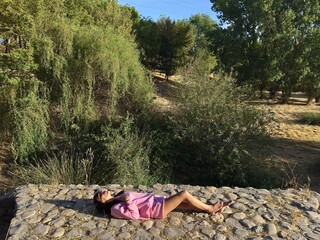 Relaxed woman lying down enjoying the sun in nature