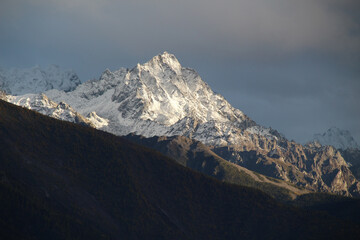 Jagged, snowy peaks loom under a cloudy sky Meili Snow Mountain Yala Snow Mountain, Sichuan, China