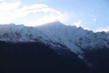 Jagged, snowy peaks loom under a cloudy sky Meili Snow Mountain Yala Snow Mountain, Sichuan, China