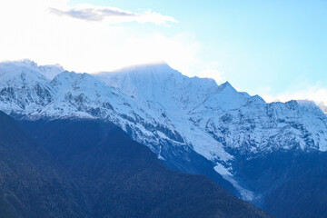 Obraz premium Jagged, snowy peaks loom under a cloudy sky Yala Snow Mountain, Sichuan, China