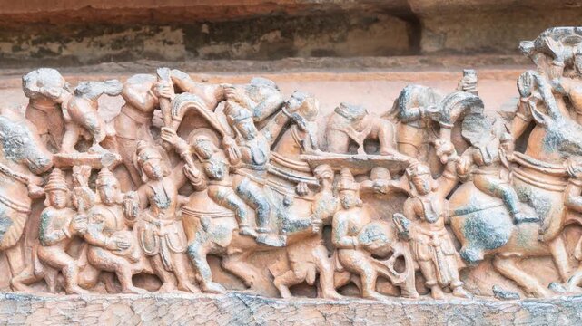 Pan: Detailed stone carving Halebeedu ancient temple Karnataka India showing warriors deities animals intricate sculptural art symbolizing heritage culture devotion