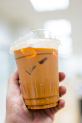 A glass of cold Thai milk tea, perfect for summer drinks on hand.