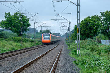 Obraz premium Saffron coloured Vande Bharat Express near Pune India. This is a made in India train set and also known as Train 18.