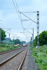 Saffron coloured Vande Bharat Express near Pune India. This is a made in India train set and also known as Train 18.