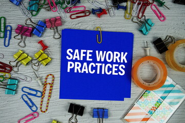 Safe Work Practices text on stick note with stationery on concrete background