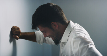 Depression, stress and business man on wall for fail, financial crisis or mental health in office....