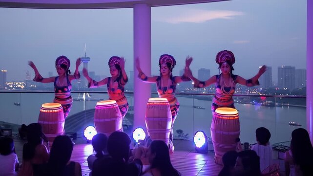 Four Women Drummers Perform on Rooftop at Dusk with City Skyline View