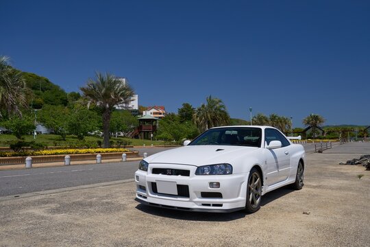 愛知、日本 - 2023年4月27日 : 春の海岸通りに日産R34型スカイラインGT-R VspecII