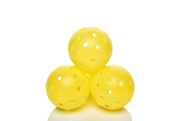 A stack of yellow Pickleball balls on white.