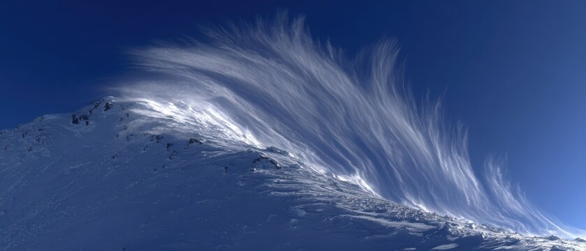 Snowy mountain peak with windblown snow and clear blue sky du daytime with sunlight and high altitude environment - Powered by Adobe