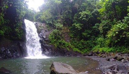 Lush waterfall cascading into a tranquil pool amidst dense tropical foliage